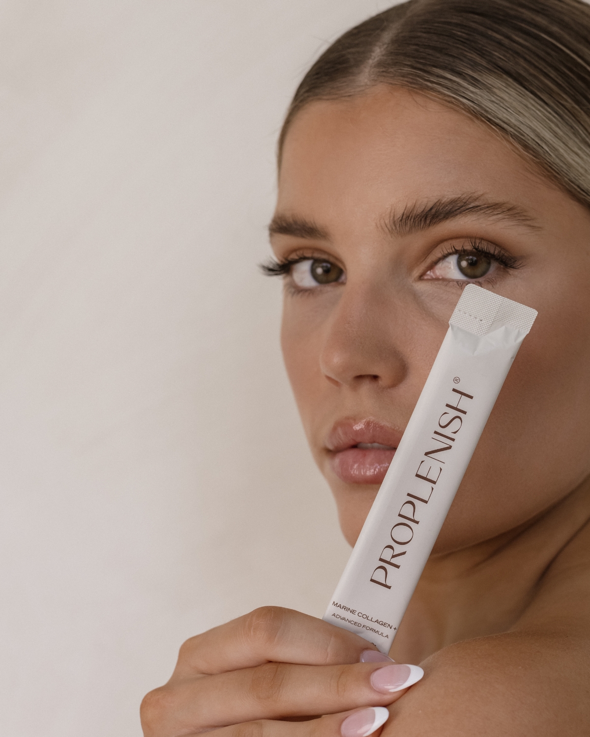 Woman holding ProPlenish Marine Collagen +